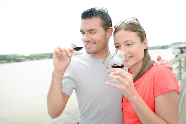 Casal beber vinho junto ao rio — Fotografia de Stock