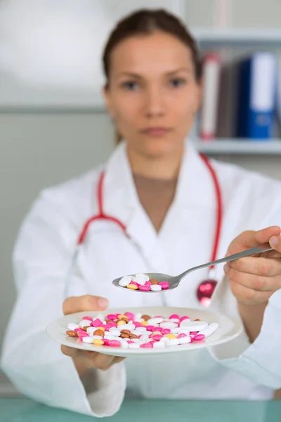 Different diet pills in white plate in female doctors hands — Stock Photo, Image