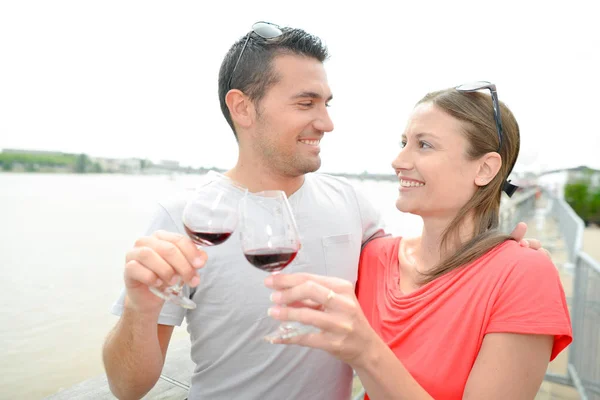 グラスワインを保持している川、横に立っていたカップル — ストック写真