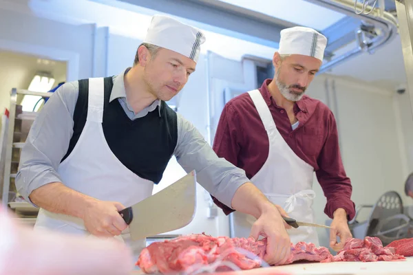 Dois açougueiros preparando carne na loja — Fotografia de Stock