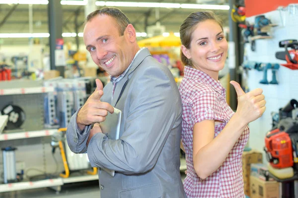 Uomo e donna in ferramenta facendo gesti positivi mano — Foto Stock