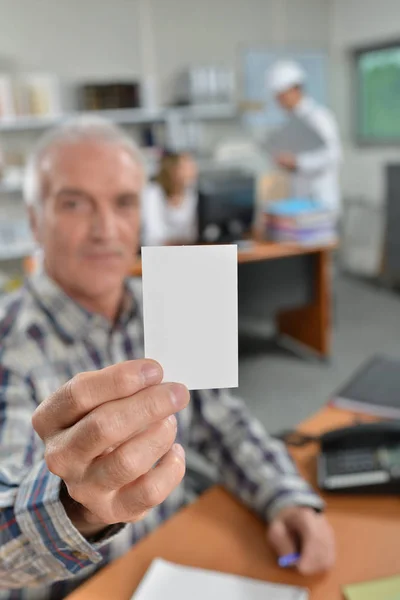 Homem segurando cartão no escritório — Fotografia de Stock