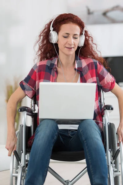 Donna disabile con computer portatile e cuffie relax a casa — Foto Stock