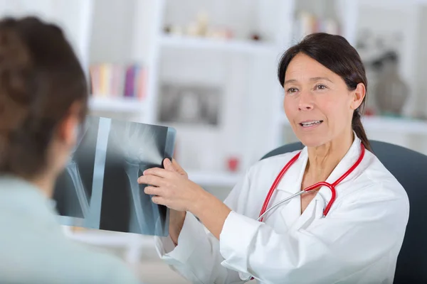 Dentista femminile che mostra le radiografie al paziente — Foto Stock