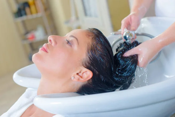 Lady lavándose el pelo en el salón — Foto de Stock