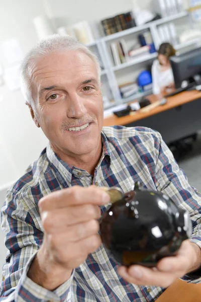 Man putting coin in a piggy bank — Stock Photo, Image