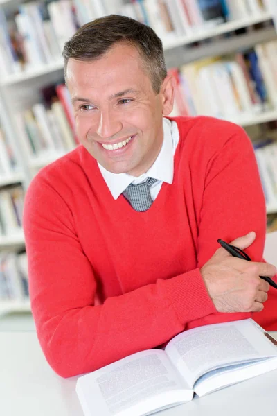 Homme dans la bibliothèque et le livre — Photo