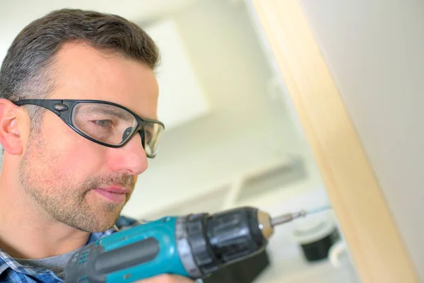 Carpenter drilling and adult — Stock Photo, Image