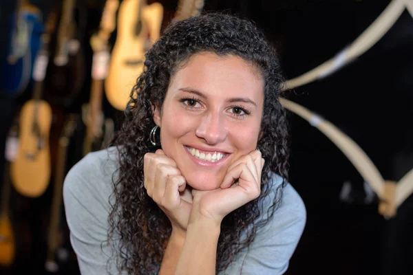 Portrait of young lady, guitars in background — Stock Photo, Image