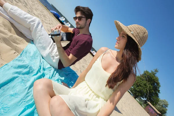 Young man with his guitar and girlfriend on the beach — Stock Photo, Image