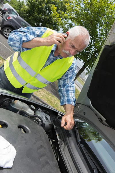 Senior sucht Hilfe bei Reparatur festgefahrenen Fahrzeugs — Stockfoto