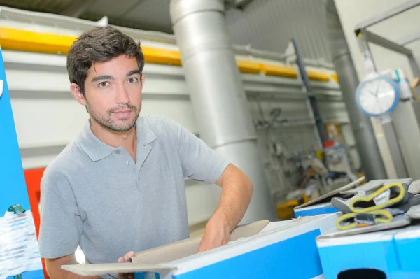 Factory worker packing carton — Stock Photo, Image