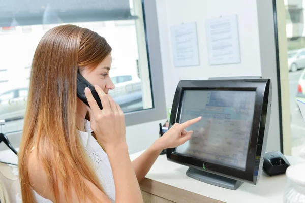 Young woman operating a till — Stock Photo, Image