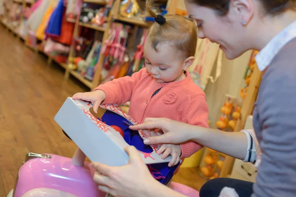 Jonge moeder haar dochter winkelen bij de speelgoedwinkel — Stockfoto