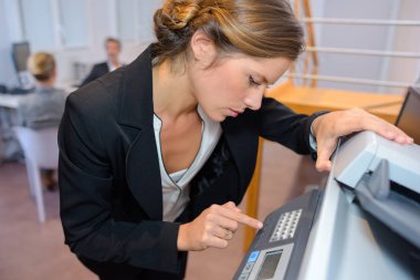 businesswoman photocopying documents in office clipart