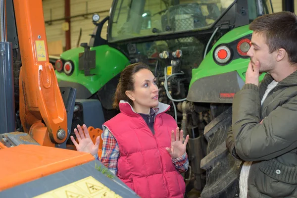 Atraente mulher vendendo novo trator para iniciante agricultor — Fotografia de Stock