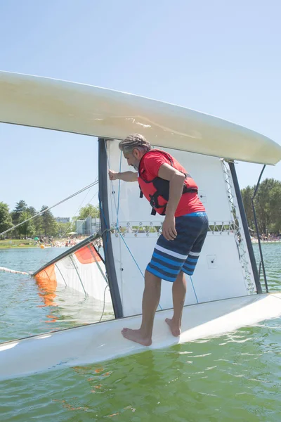 Salior trying to right his catamaran after capsize — Stock Photo, Image