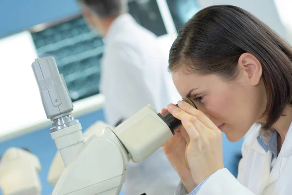 Mirando a través del microscopio y el laboratorio — Foto de Stock