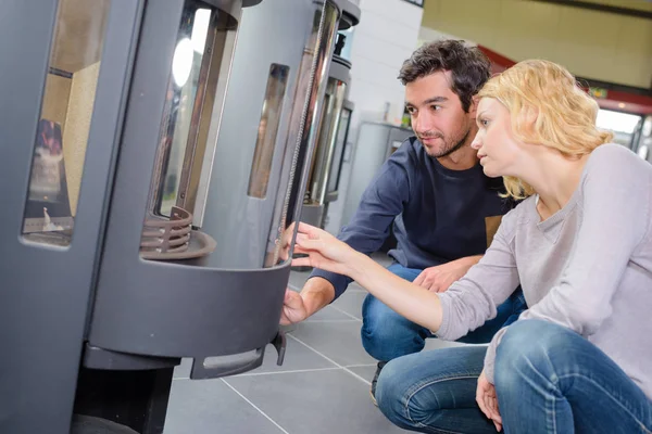 Young couple looking at woodburners — Stock Photo, Image