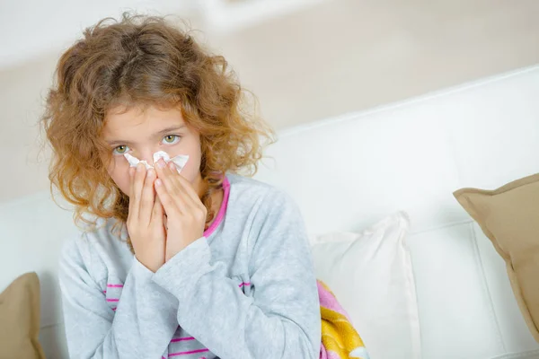 Young girl blowing nose with tissue — Stock Photo, Image