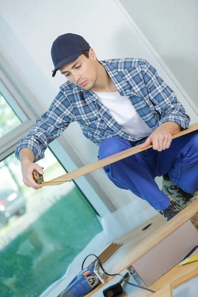 Jeune technicien installant le plancher sur le chantier — Photo