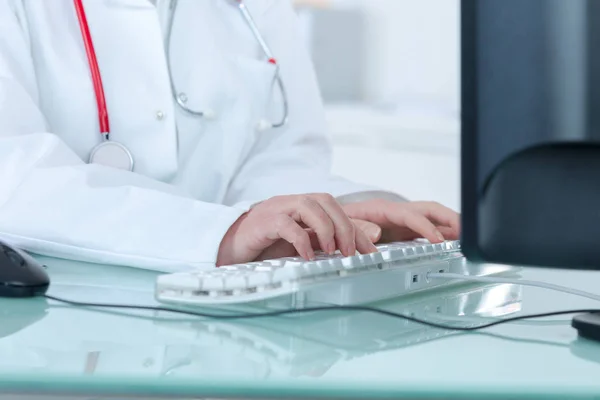 Médico feminino sentado na mesa — Fotografia de Stock