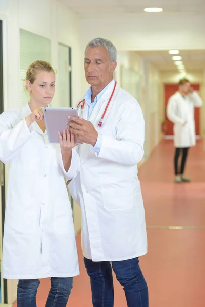 Två sjukvårdare om delegering i korridor — Stockfoto
