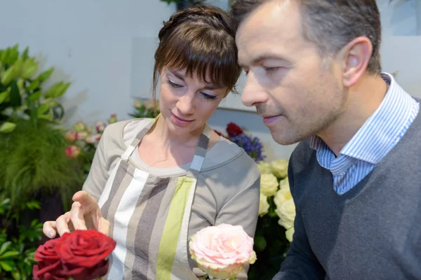 Hombre eligiendo rosas en la floristería — Foto de Stock