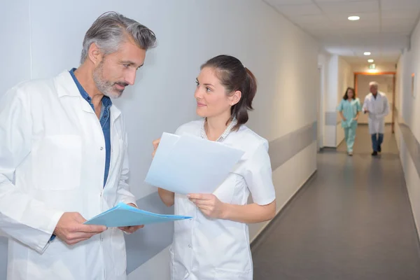 Медики розмовляють в лікарняному коридорі — стокове фото