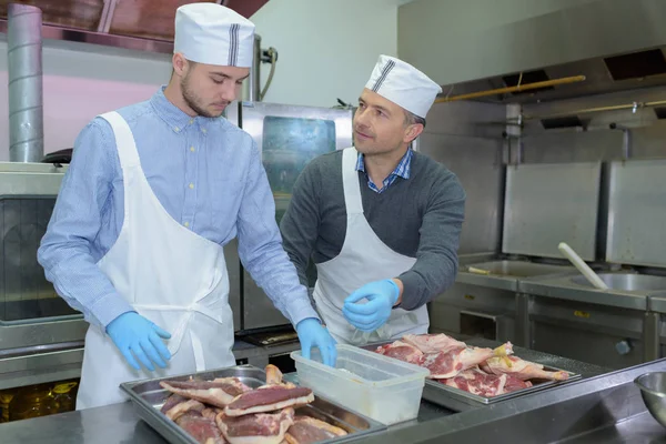 Professionelle Männer bereiten Fleisch zu — Stockfoto