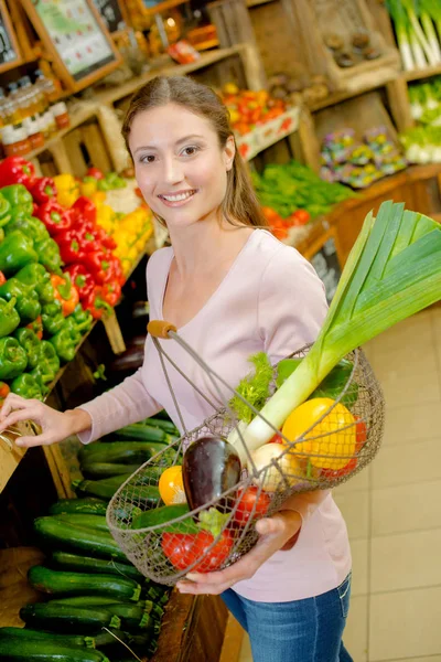 Mulher compras legumes e jovens — Fotografia de Stock