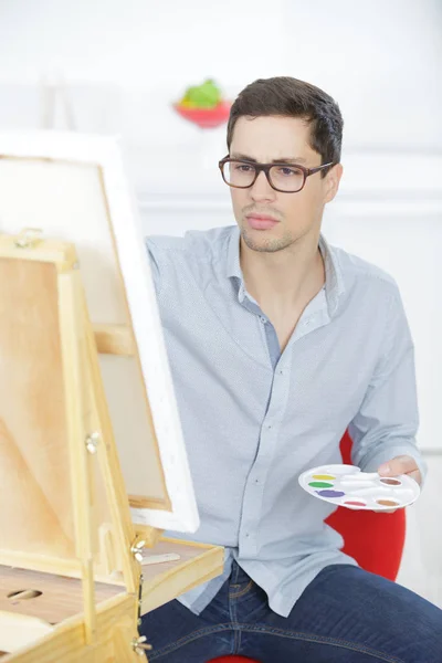 Portret van een jonge mannelijke artiest op het werk — Stockfoto