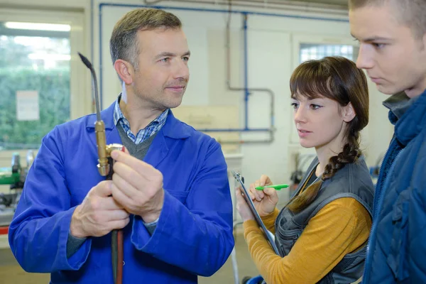 Ironworks teacher showing students how to securely use gas welder — Stock Photo, Image