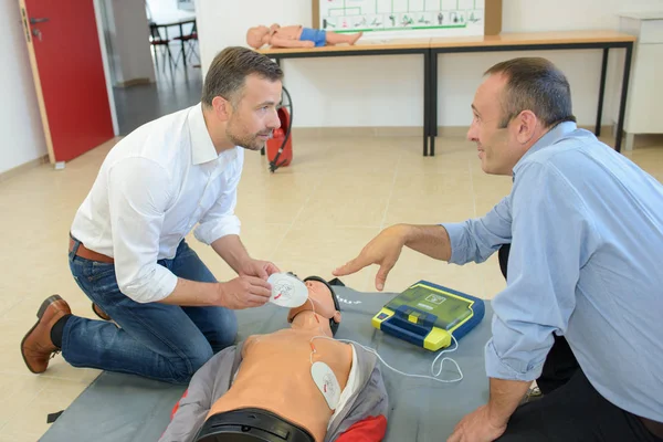 Men training to use defibrillator — Stock Photo, Image