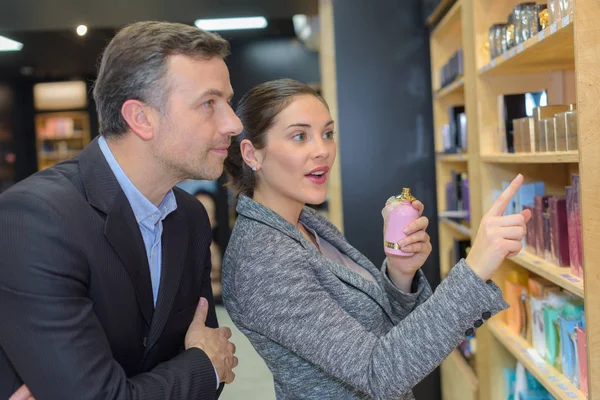 man with assistant help choosing beauty products at beauty shop