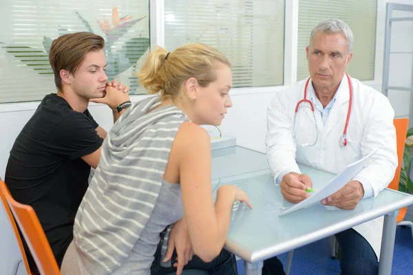 Médico em consulta com casal — Fotografia de Stock