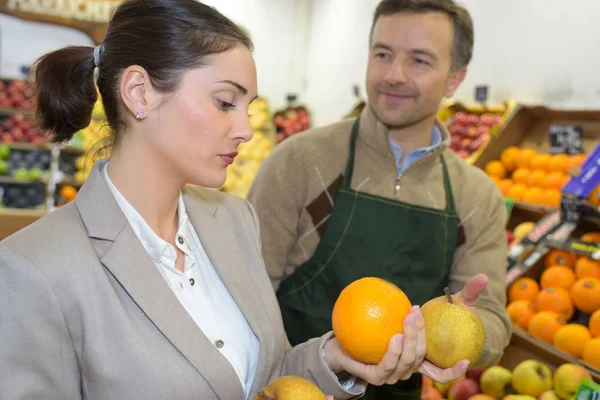 店员向顾客传递葡萄柚 — 图库照片