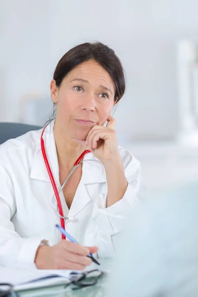 Женщина-врач слушает свой кабинет — стоковое фото