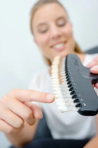 Jonge vrouw wijzend op een item — Stockfoto