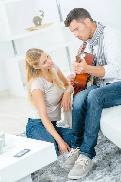 Homem tocando guitarra para senhora — Fotografia de Stock