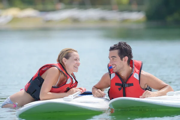 Feliz pareja y sus tablas de paddle — Foto de Stock