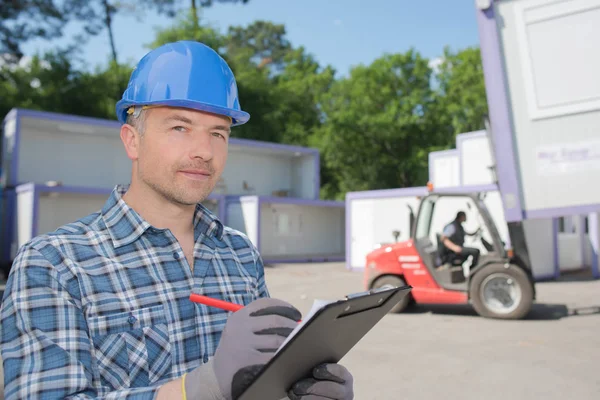 Hombre usando hardhat sujetando portapapeles — Foto de Stock