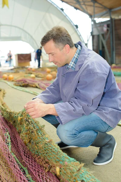 Fisherman inspecting nets and fisherman — Stock Photo, Image