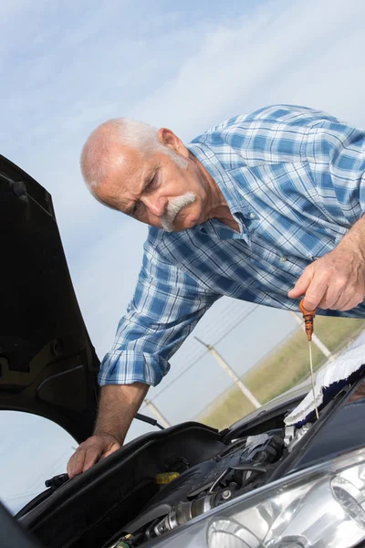 Uomo anziano controllare i livelli del motore auto — Foto Stock
