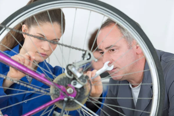 Leerling monteur kijken fietswiel — Stockfoto