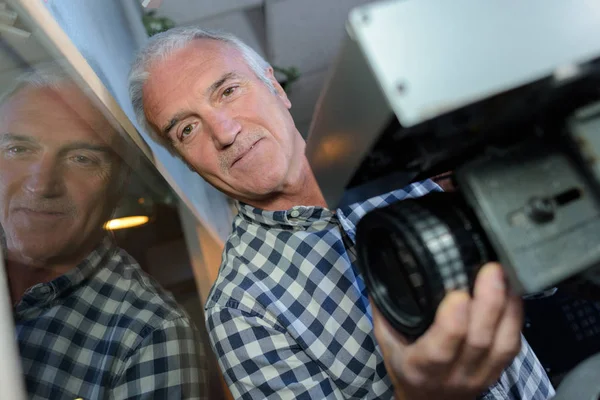 Camaraman adjusting lens on camera — Stock Photo, Image