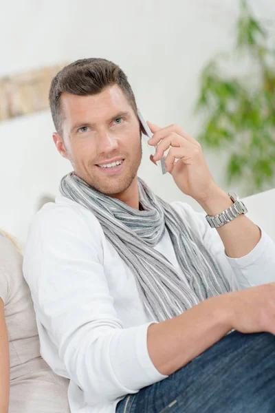 Man sat on his sofa taking a call — Stock Photo, Image