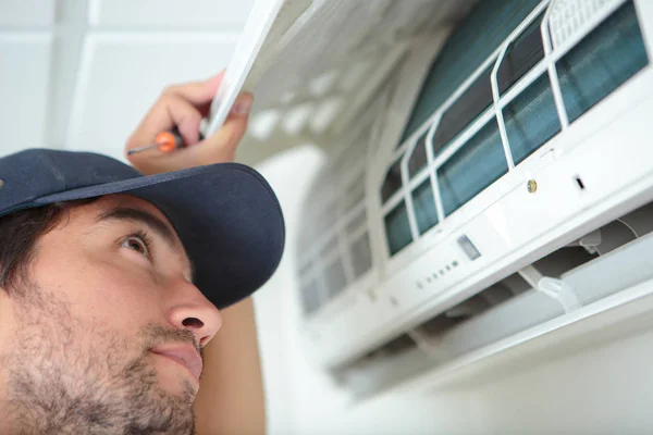 Muž provádějící kontrolu klimatizační jednotka — Stock fotografie