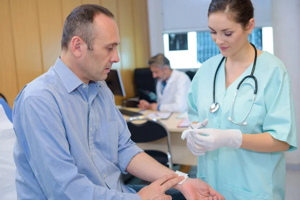 Asistente médico poniendo un apósito —  Fotos de Stock