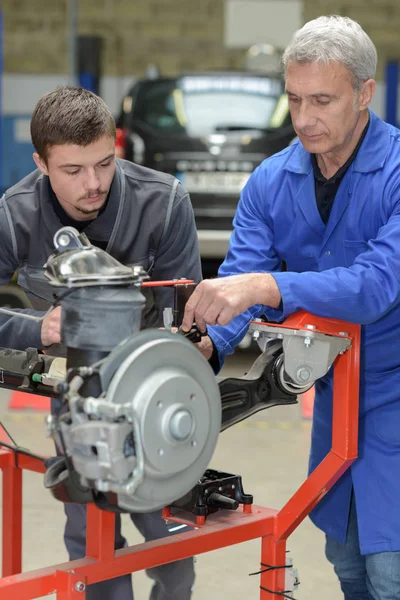 Onderwijzer en student in auto mechanica opleiding klasse — Stockfoto